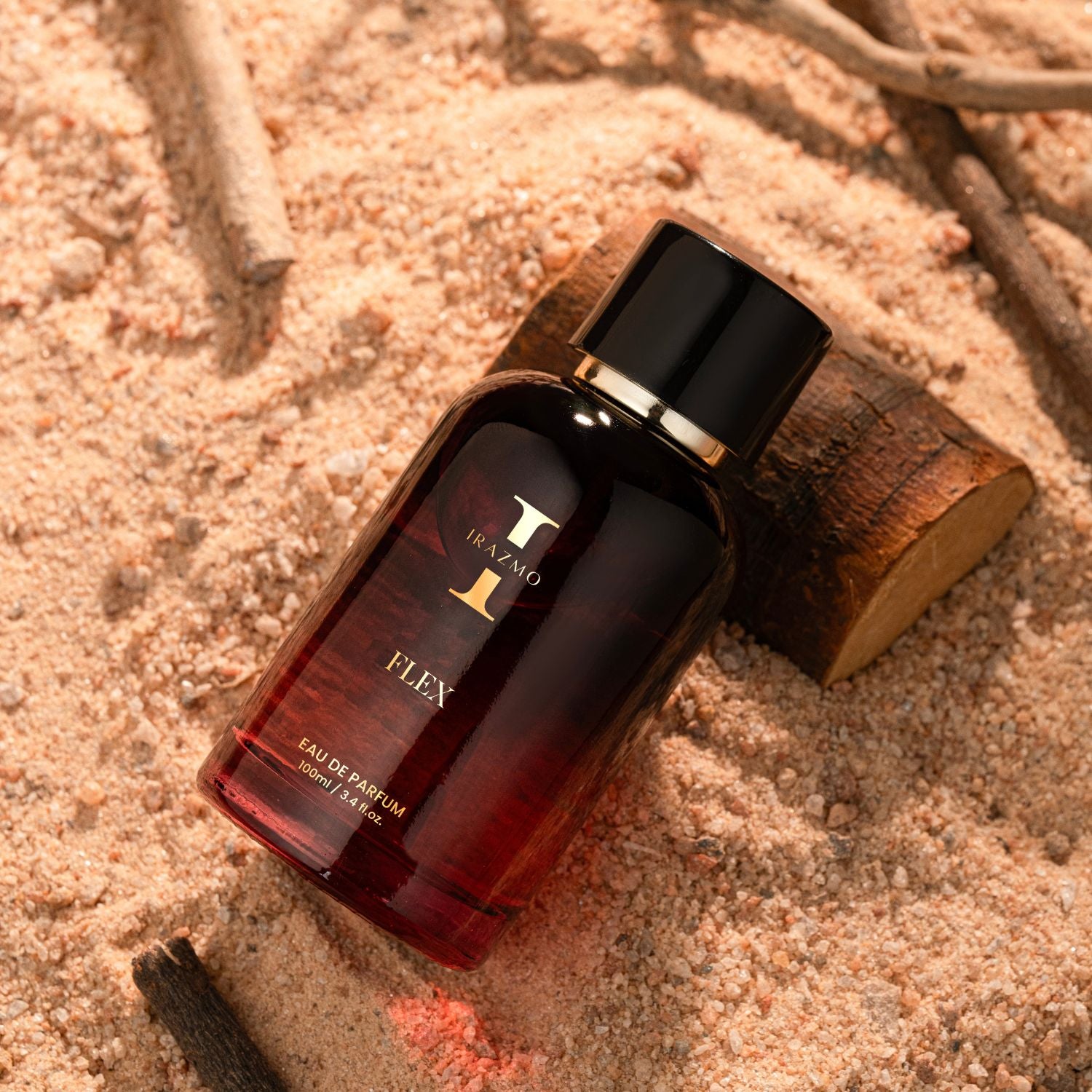 Perfume bottle labeled 'Flex' by DKNY on a sandy surface