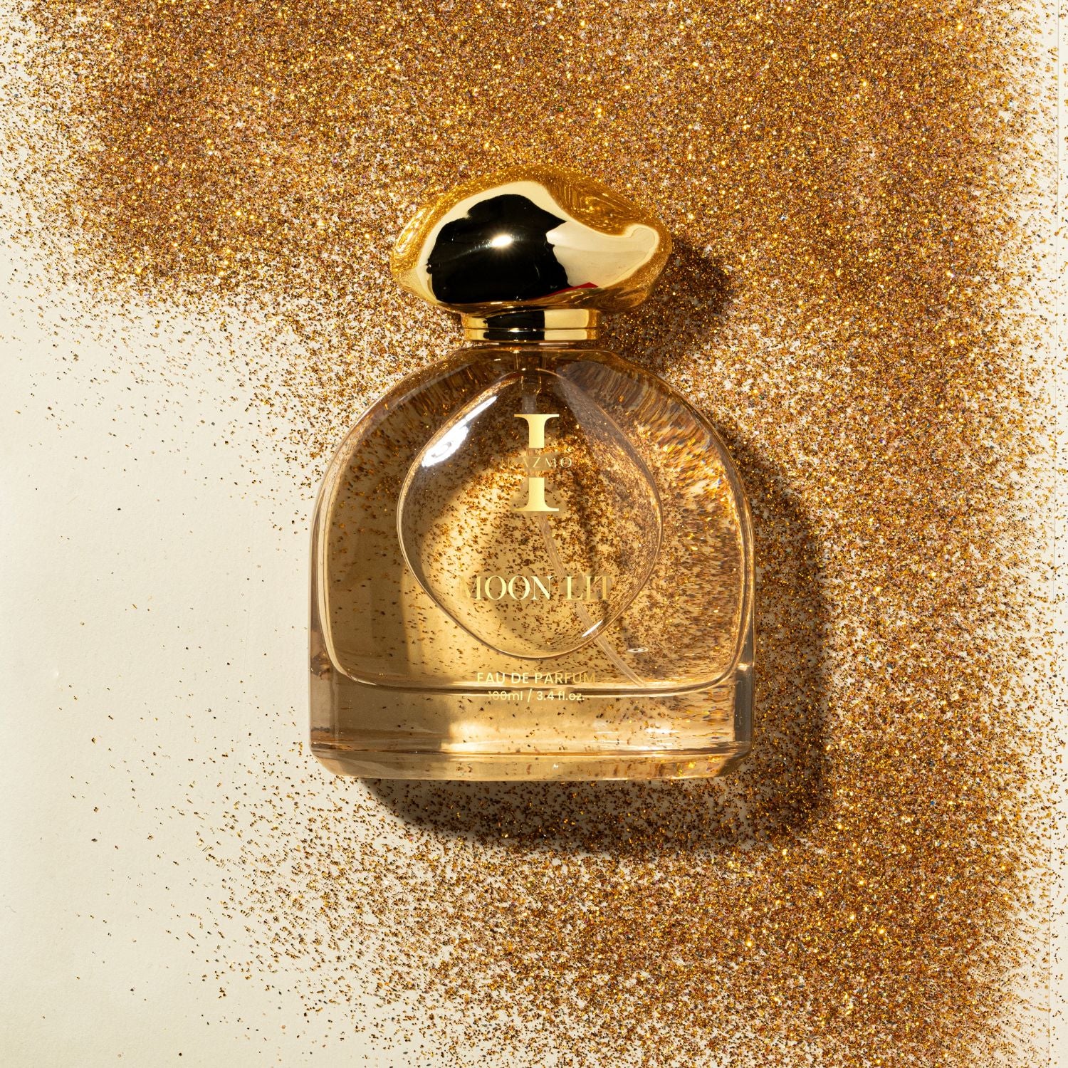 Gold perfume bottle with a glittery gold background