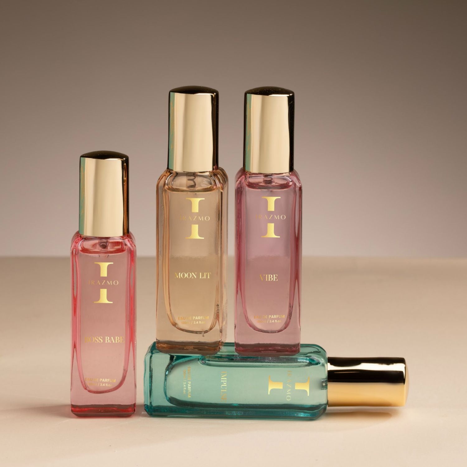 Set of perfume bottles with gold caps on a beige background