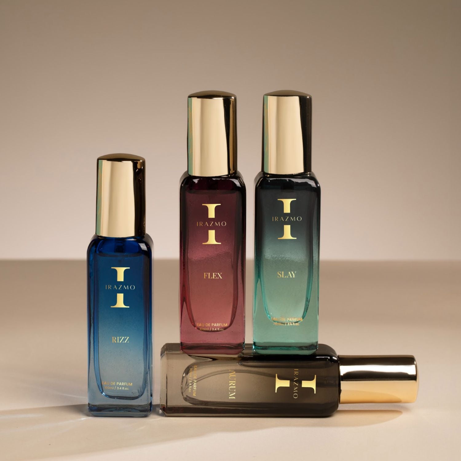 Four perfume bottles with gold caps on a beige background