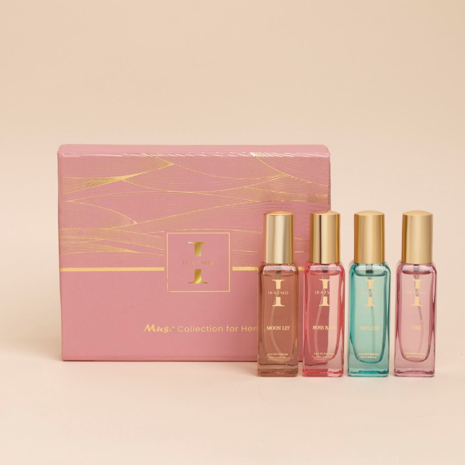 Set of four perfume bottles with a pink packaging box on a beige background
