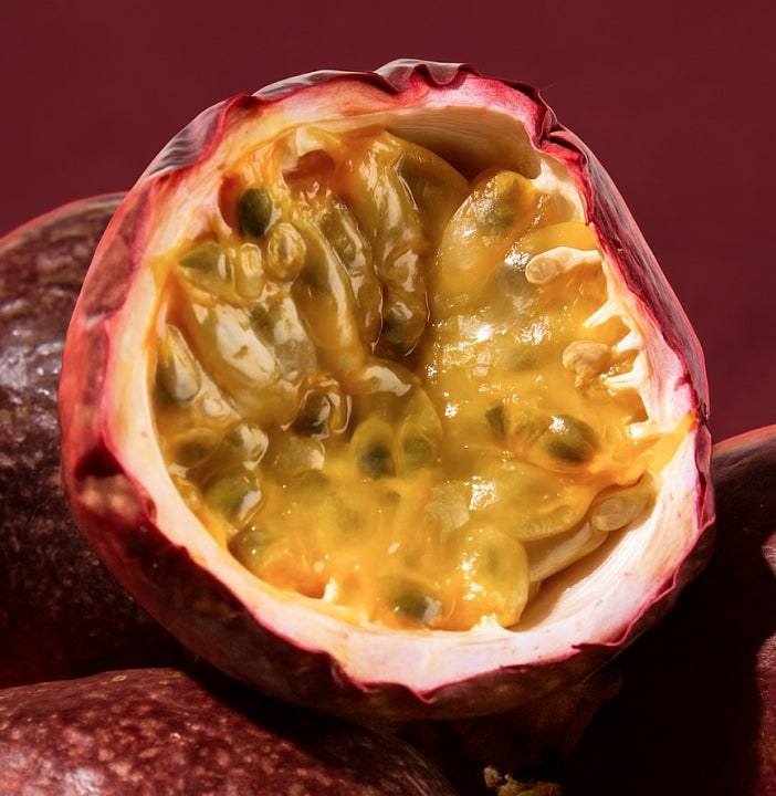 Halved passion fruit with juicy interior on a dark background
