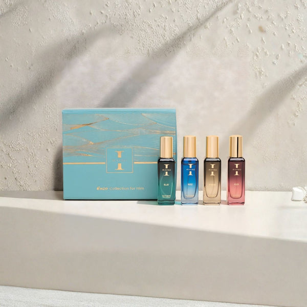 Set of four perfume bottles with a decorative box on a light surface.