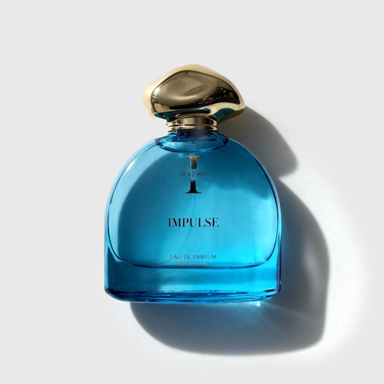 Blue perfume bottle with gold cap on a light gray background