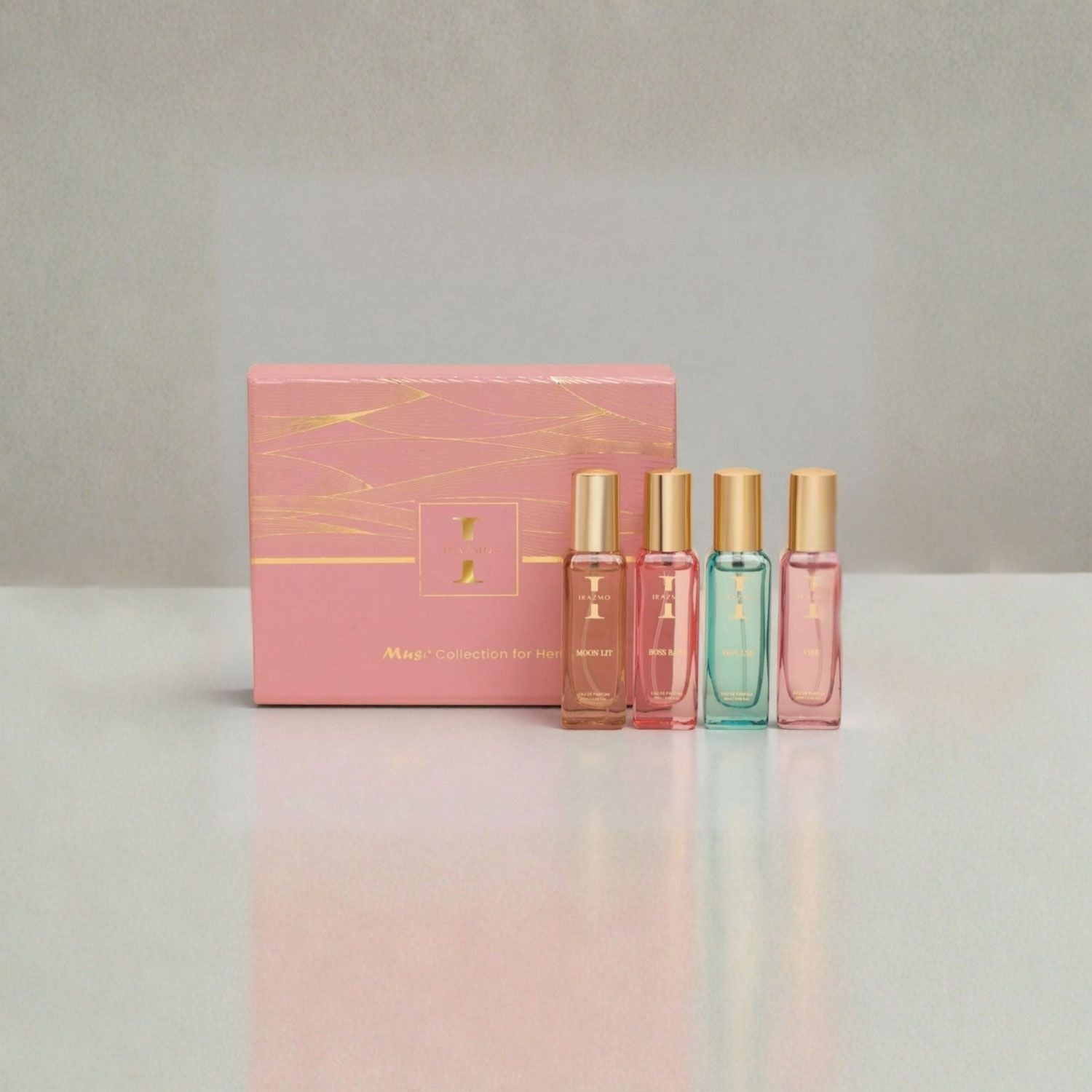 Set of four perfume bottles with a pink box on a gradient background