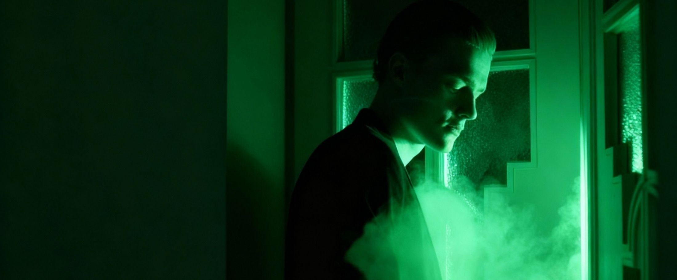 Person standing in a dimly lit room with greenish hue