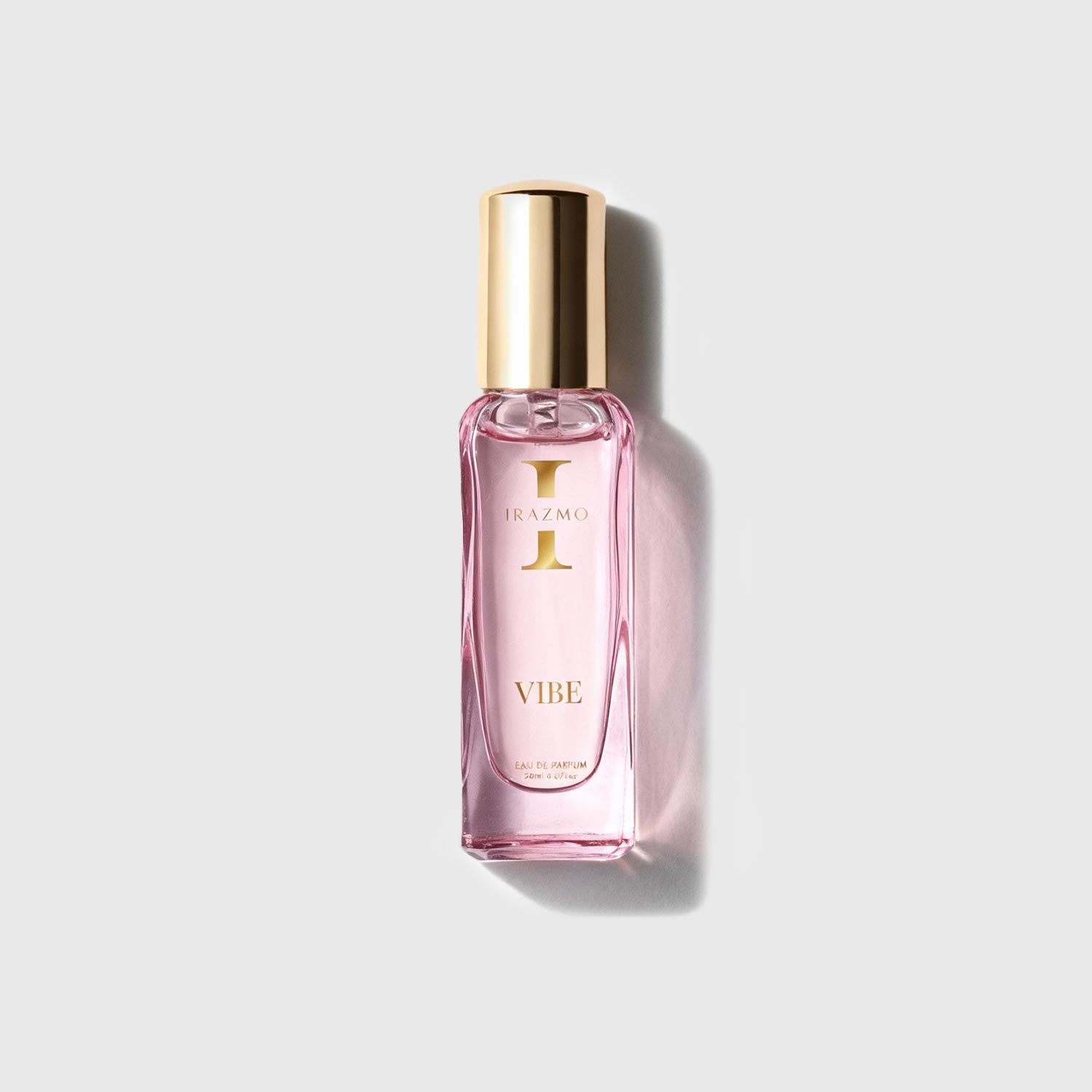 Pink perfume bottle with gold cap on a light gray background
