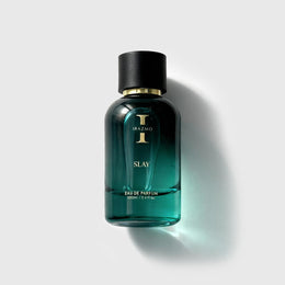 Green perfume bottle with black cap on a light gray background