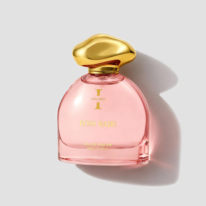 Pink perfume bottle with gold cap on a light gray background